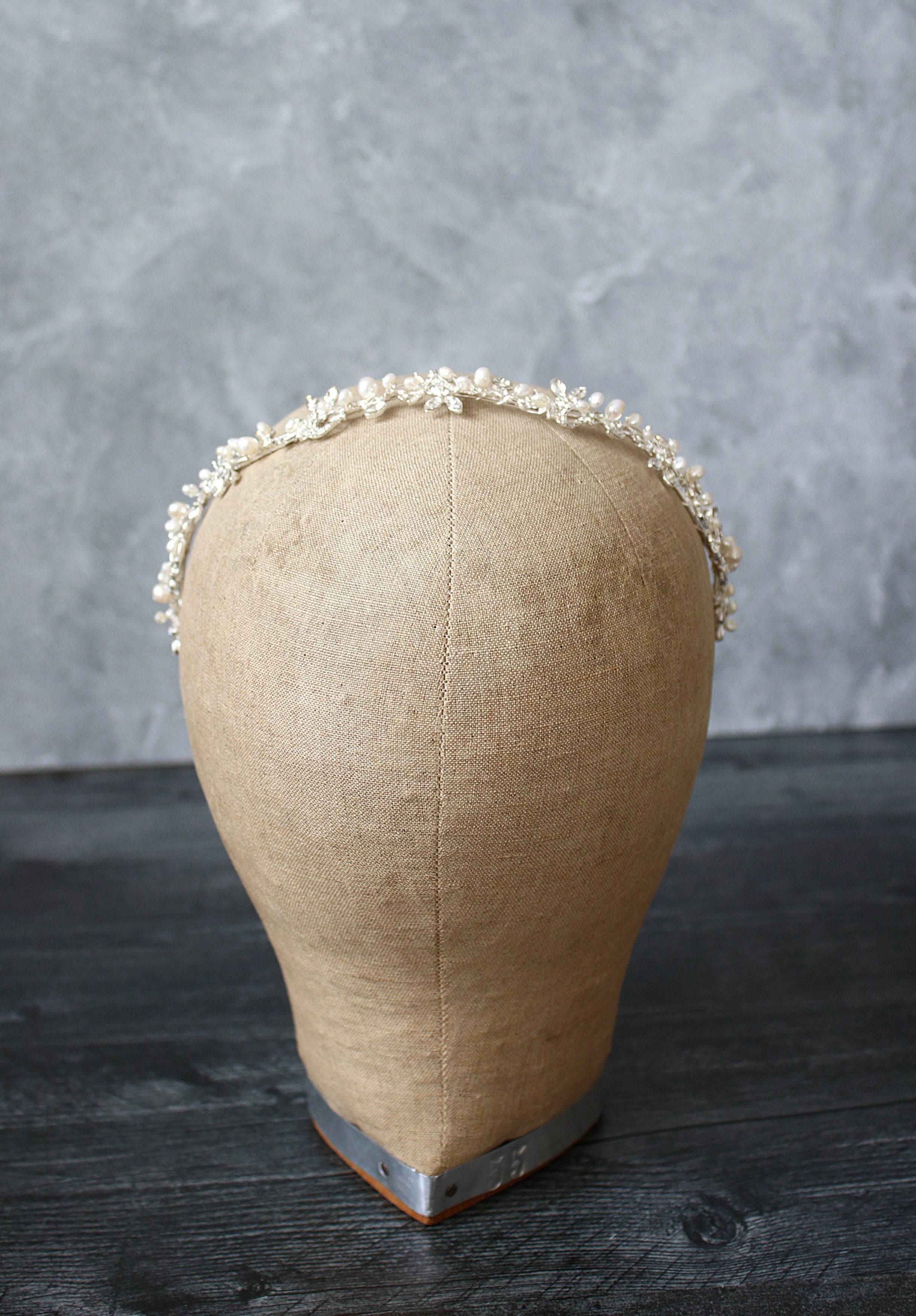 Freshwater pearl bridal headband with crystals in silver, elegantly worn by a model. Perfect wedding headpiece for timeless bridal style.