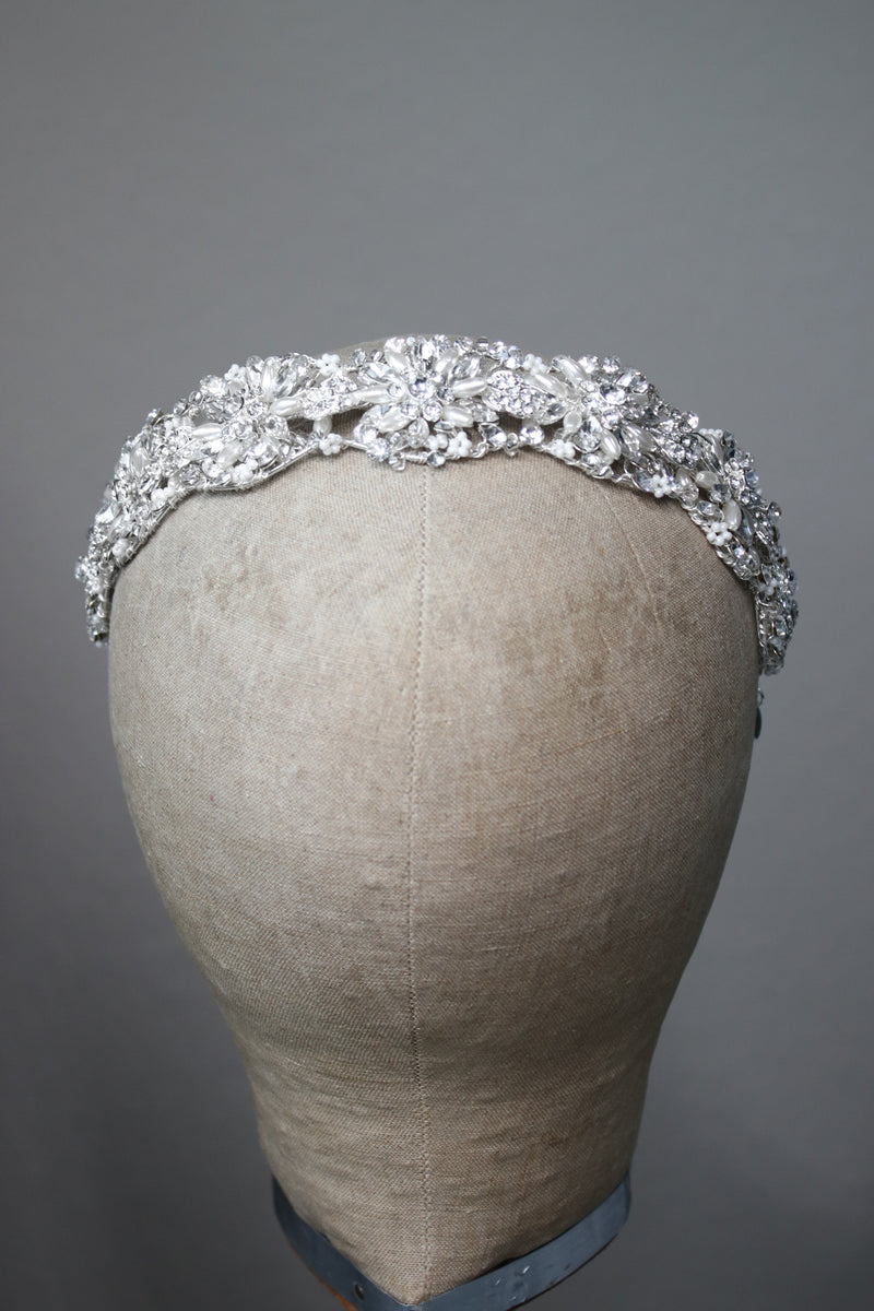 Front view of the CLARISSA bridal headband with shimmering crystal and pearl accents in a floral motif on a silver base.