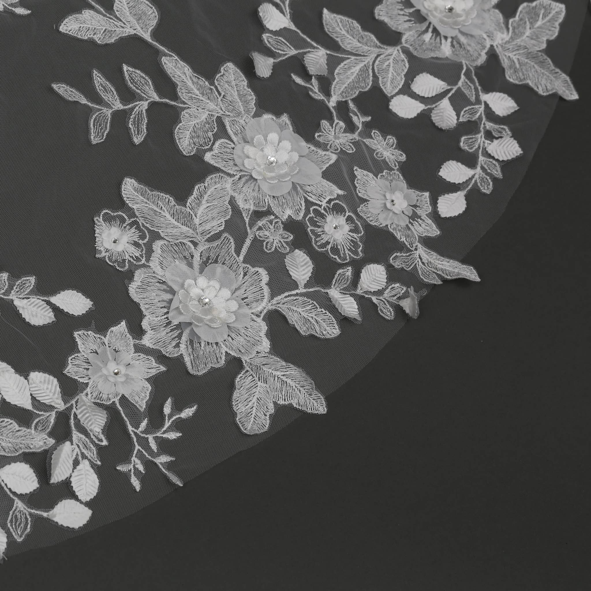Close-up of embroidered lace and 3D floral appliqué on pale ivory veil. | EDEN LUXE Bridal