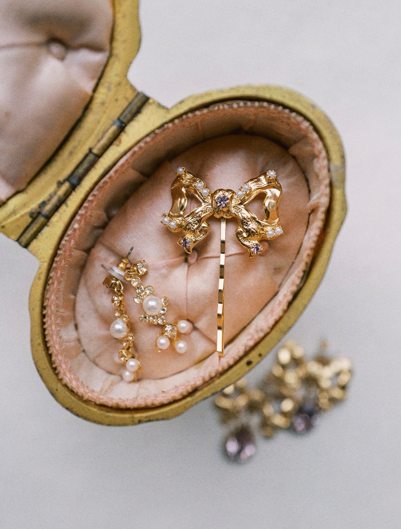 Gold hairpin with decorative elements in a heart-shaped jewelry box on a light background
