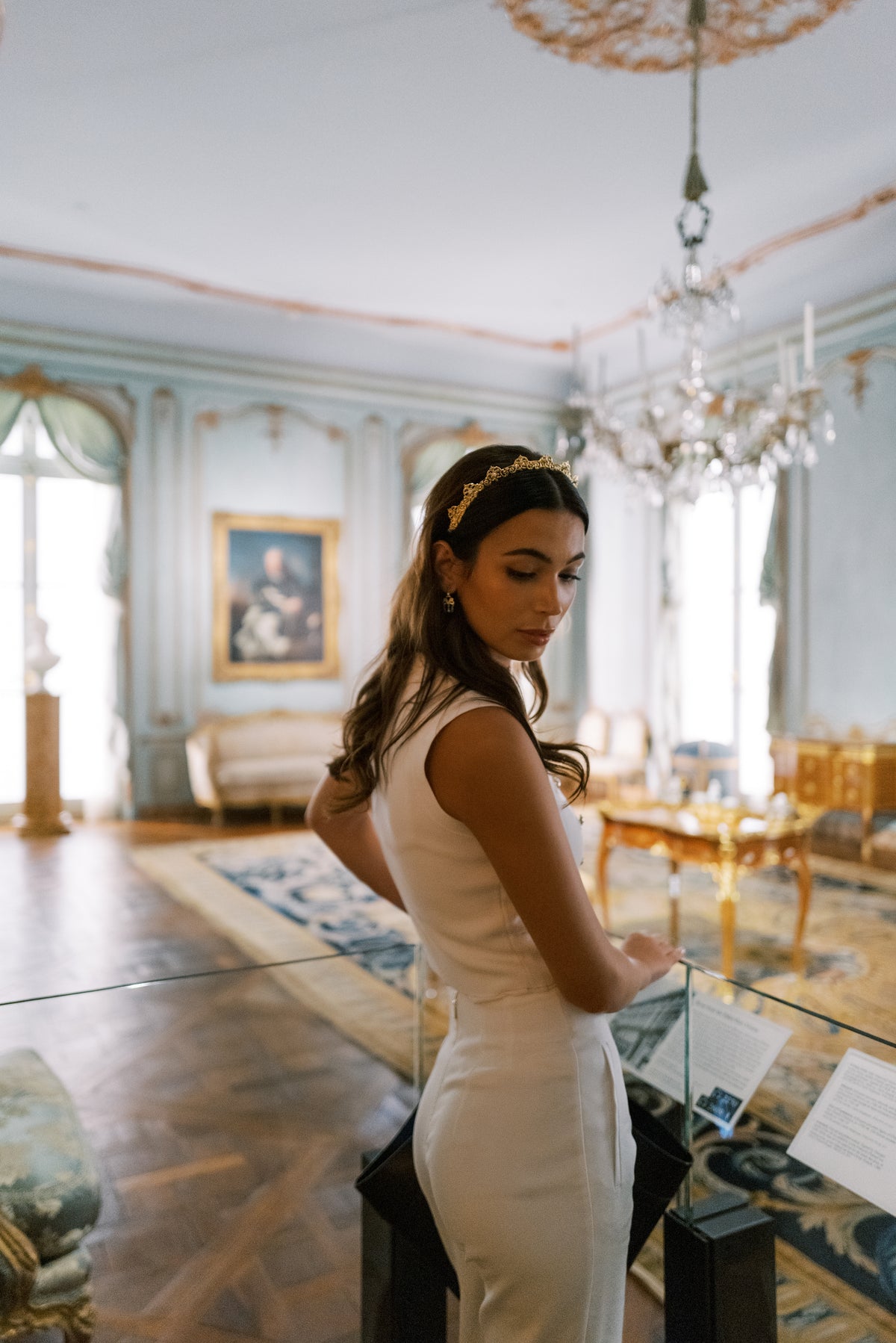 Antoinette Halo Everyday Tiara worn beneath a crystal chandelier in the 18th-century French period rooms at The Metropolitan Museum of Art, luxury gold headband for holiday parties and galas | EDEN LUXE Bridal