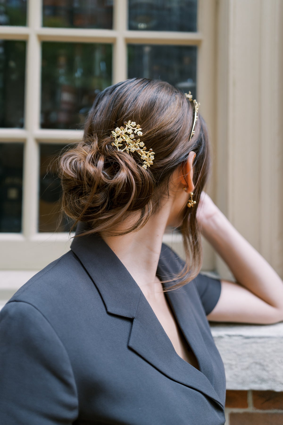Deborah Barrette, a 14k gold plated topaz and golden shadow Swarovski crystal hair clip, worn in a low chignon beside a historic window, Sophie Kaye x EDEN LUXE Revolution Collection | EDEN LUXE Bridal