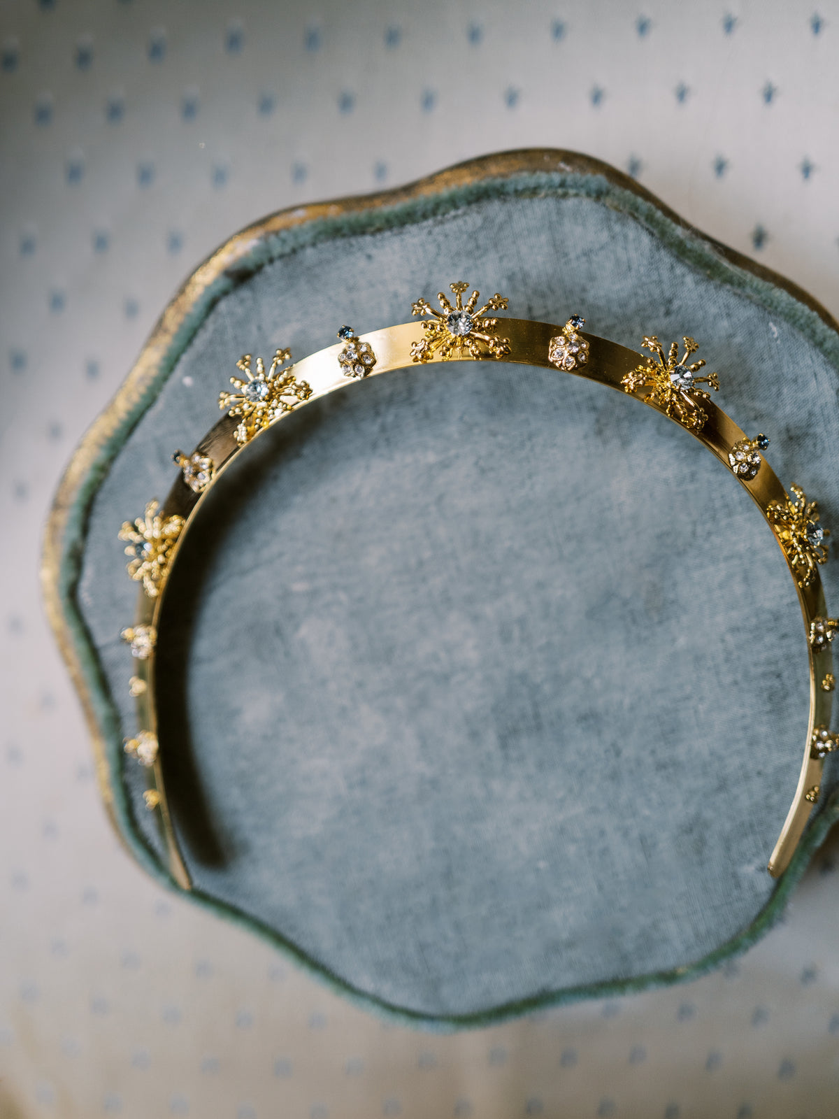 Madame Brillon Everyday Tiara flat lay on an antique green velvet tray, 14k gold plated headband with French blue Swarovski crystal fireworks bursts | EDEN LUXE Bridal
