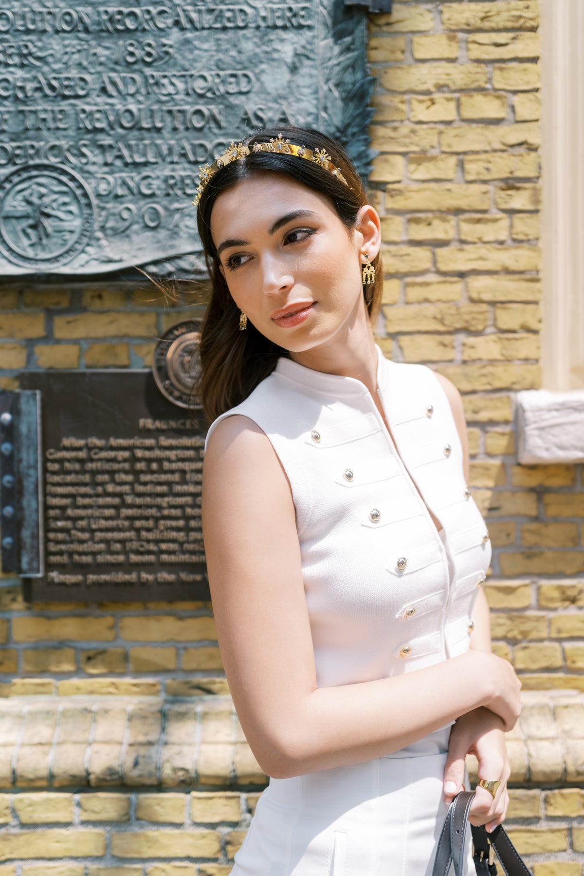 Model in white wearing the Madame Brillon gold and French blue crystal headband at Fraunces Tavern, Lower Manhattan, luxury headband for holiday parties and red carpet galas | EDEN LUXE Bridal