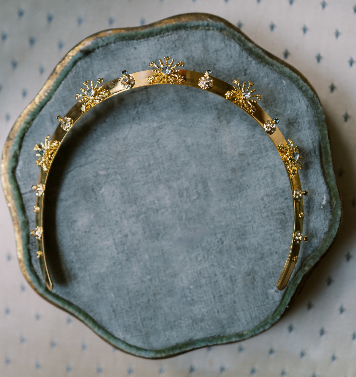 Overhead detail of the Madame Brillon gold fireworks headband on green velvet, luxury hair accessory and holiday gift for her by Sophie Kaye x EDEN LUXE | EDEN LUXE Bridal
